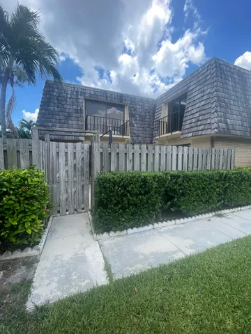 a view of a pathway of a house with a yard and plants
