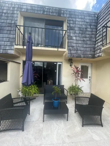 a view of a house with a yard and sitting area