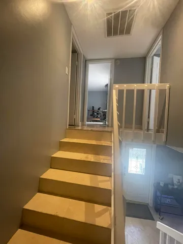 a view of staircase with lots of frames on wall