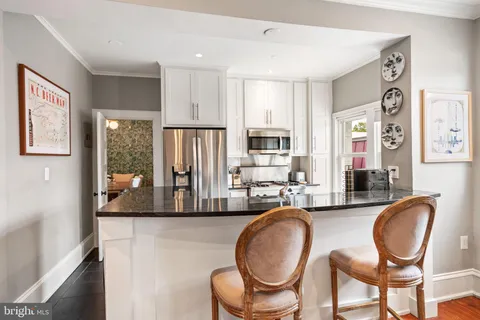 a living room with furniture a flat screen tv and large window