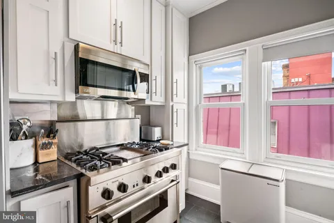 a kitchen with stainless steel appliances a stove and a microwave
