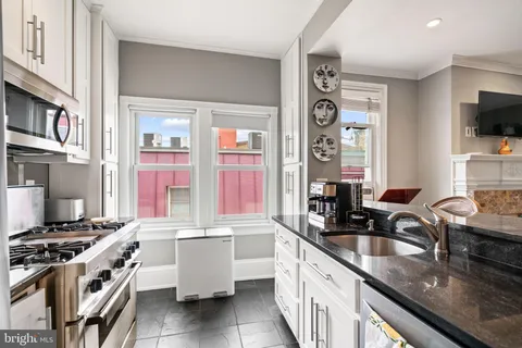 a kitchen with stainless steel appliances granite countertop a sink stove and cabinets
