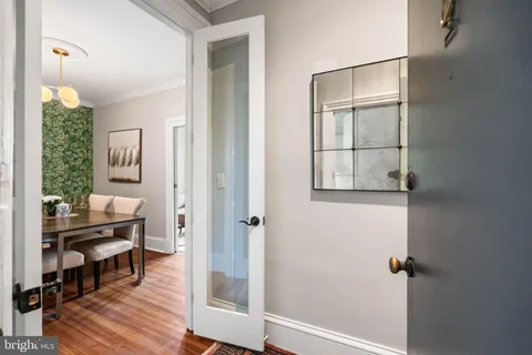 a view of a hallway with wooden floor and a bathroom