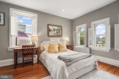 a bedroom with a bed and a large window