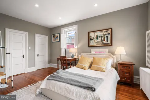 a bedroom with a bed and a painting on the wall