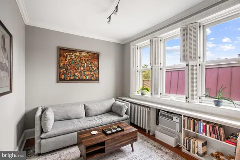 a living room with furniture a large window and a book shelf