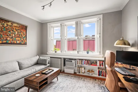 a living room with furniture a flat screen tv and a window
