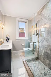 a bathroom with a granite countertop sink mirror vanity and toilet