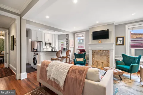 a living room with furniture a fireplace and a flat screen tv