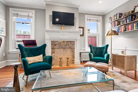 a living room with furniture a flat screen tv and a fireplace