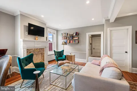 a living room with furniture a flat screen tv and a fireplace