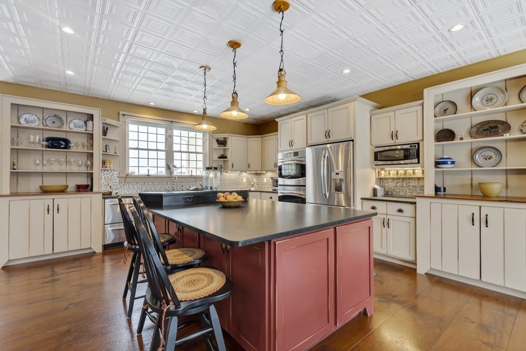 35 Piasta Road Dudley, MA 01571 - Photo 8 of 42 a kitchen with stainless steel appliances granite countertop a sink a stove a refrigerator cabinets and dining table with wooden floor