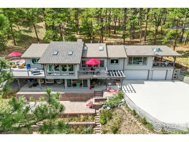an aerial view of a house with swimming pool and large trees