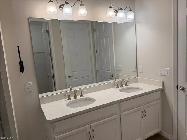 a bathroom with 2 sink and a mirror