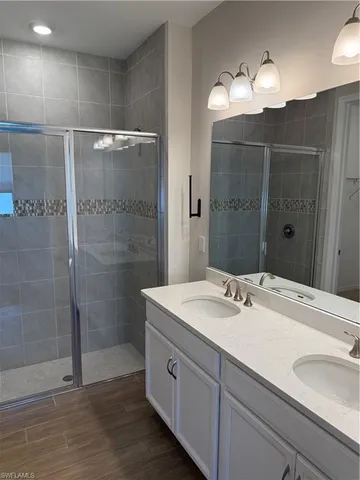 a bathroom with a sink shower and a mirror