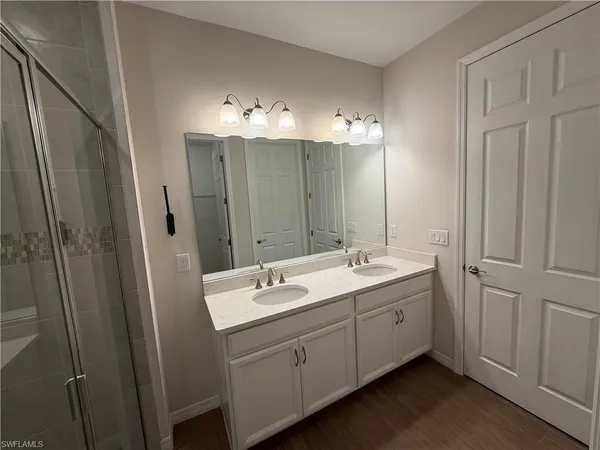 a bathroom with a double vanity sink and mirror
