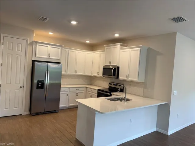 a kitchen with stainless steel appliances a refrigerator sink and microwave