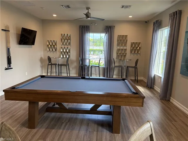 a living room with furniture pool table and a flat screen tv