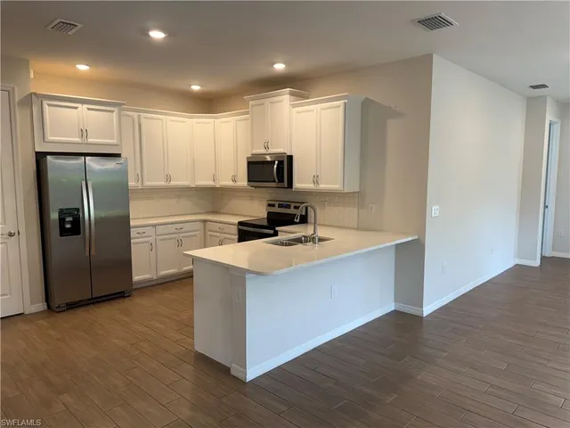 a kitchen with stainless steel appliances a refrigerator stove and microwave