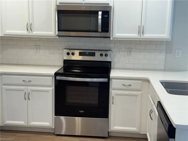 a kitchen with stainless steel appliances a stove microwave and sink