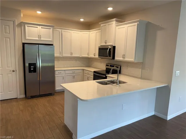 a kitchen with kitchen island a sink appliances and cabinets