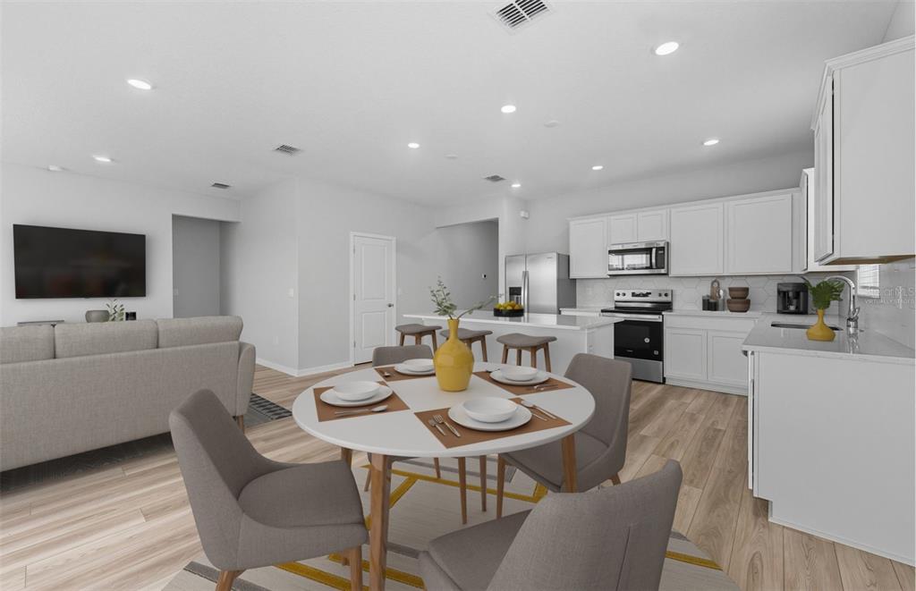 8343 Southwest 58 Loop Ocala, FL 34481 - Photo 2 of 34 a kitchen with stainless steel appliances kitchen island granite countertop a dining table chairs microwave and sink