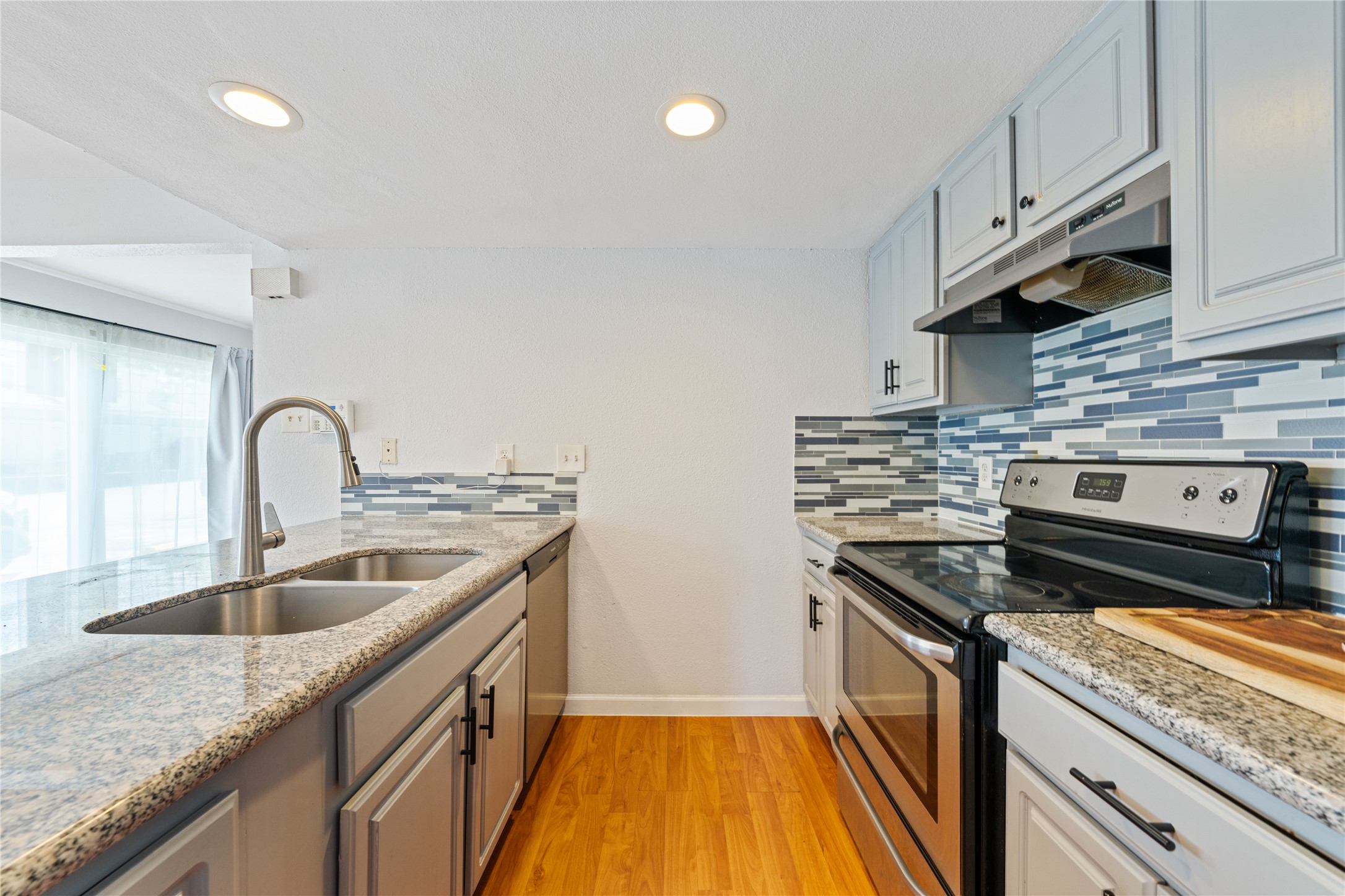 2124 Burton Drive, Unit 159 Austin, TX 78741 - Photo 10 of 23 A well-appointed kitchen features ample counter space, modern appliances, and rich wood flooring.