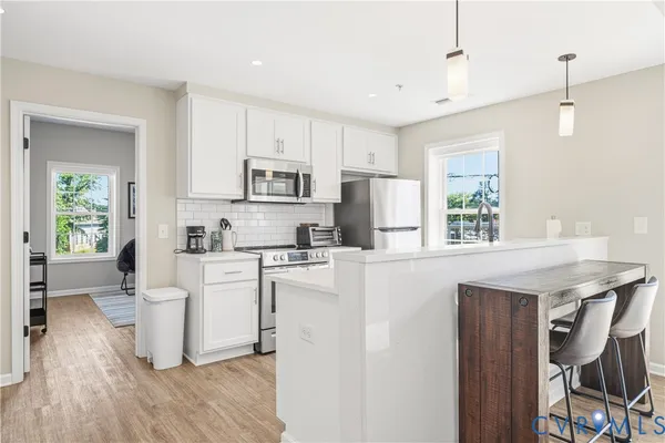 a kitchen with kitchen island a white cabinets and wooden floor