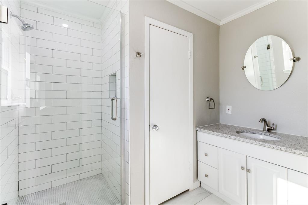 11236 Quail Run Street Dallas, TX 75238 - Photo 18 of 25 a bathroom with a granite countertop sink a mirror and shower