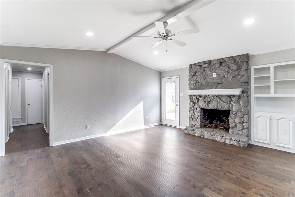 11236 Quail Run Street Dallas, TX 75238 - Photo 5 of 25 a view of an empty room with wooden floor fireplace and a window