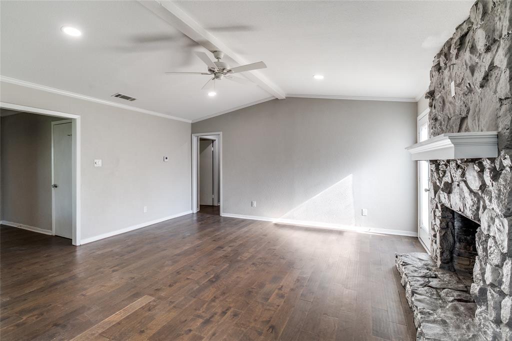 11236 Quail Run Street Dallas, TX 75238 - Photo 6 of 25 a view of an empty room with wooden floor fireplace and a window