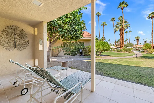 a view of an house with backyard space and tree in the background