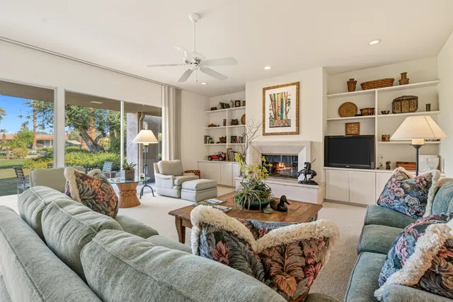 a living room with furniture fireplace and a large window
