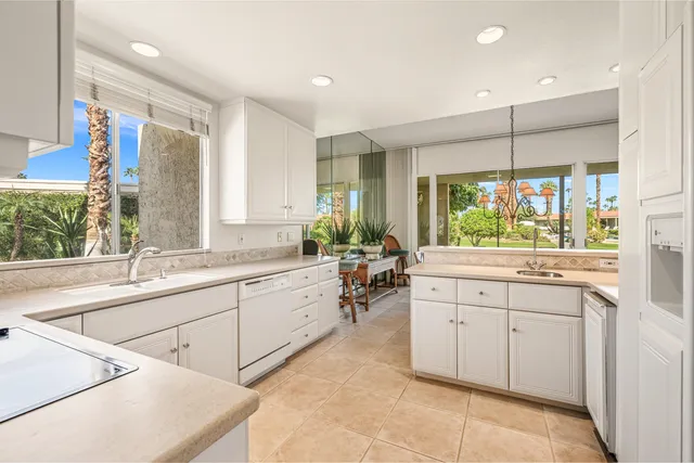 a large white kitchen with a large window