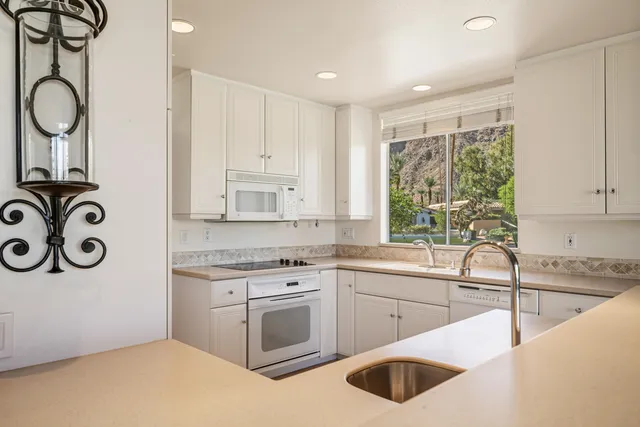 a kitchen with white cabinets a sink and a stove