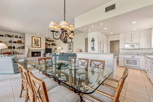 a view of a dining room and livingroom with furniture wooden floor a chandelier