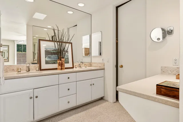 a spacious bathroom with double sink and a mirror