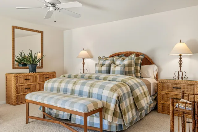 a bedroom with a bed a mirror on dresser and a chandelier