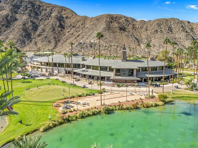 a view of a house with a big yard and large trees