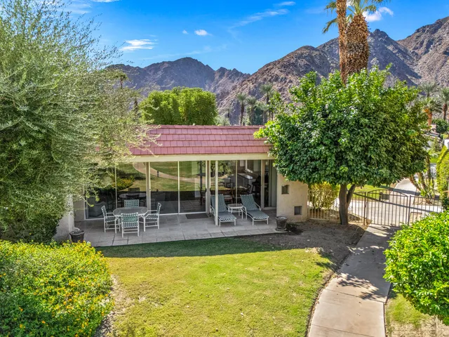 a view of a chairs and table in patio with a swimming pool