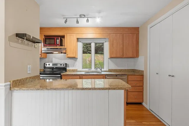 a kitchen with kitchen island granite countertop a sink cabinets and window