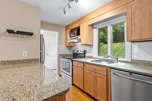 a kitchen with stainless steel appliances granite countertop a sink stove and refrigerator