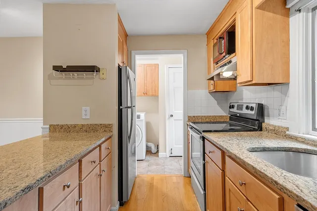 a kitchen with granite countertop a sink stove and refrigerator