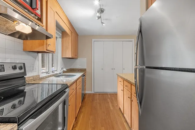 a kitchen with stainless steel appliances granite countertop a sink stove and refrigerator