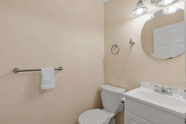 a bathroom with a toilet a sink and mirror