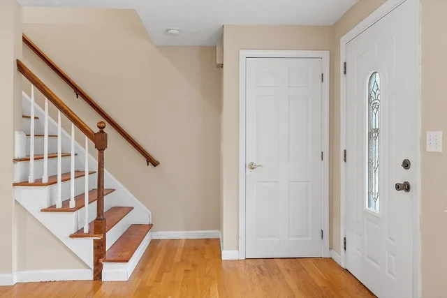 a view of front door with wooden floor and stairs