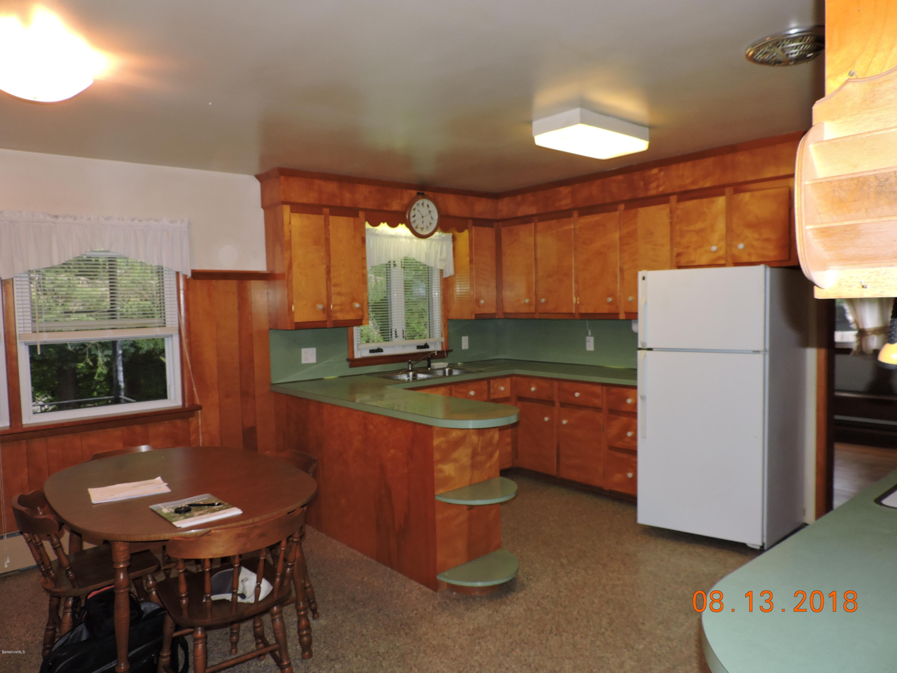 14 Calumet Street Pittsfield, MA 01201 - Photo 10 of 26 a kitchen with stainless steel appliances granite countertop a refrigerator a sink a stove a dining table and chairs