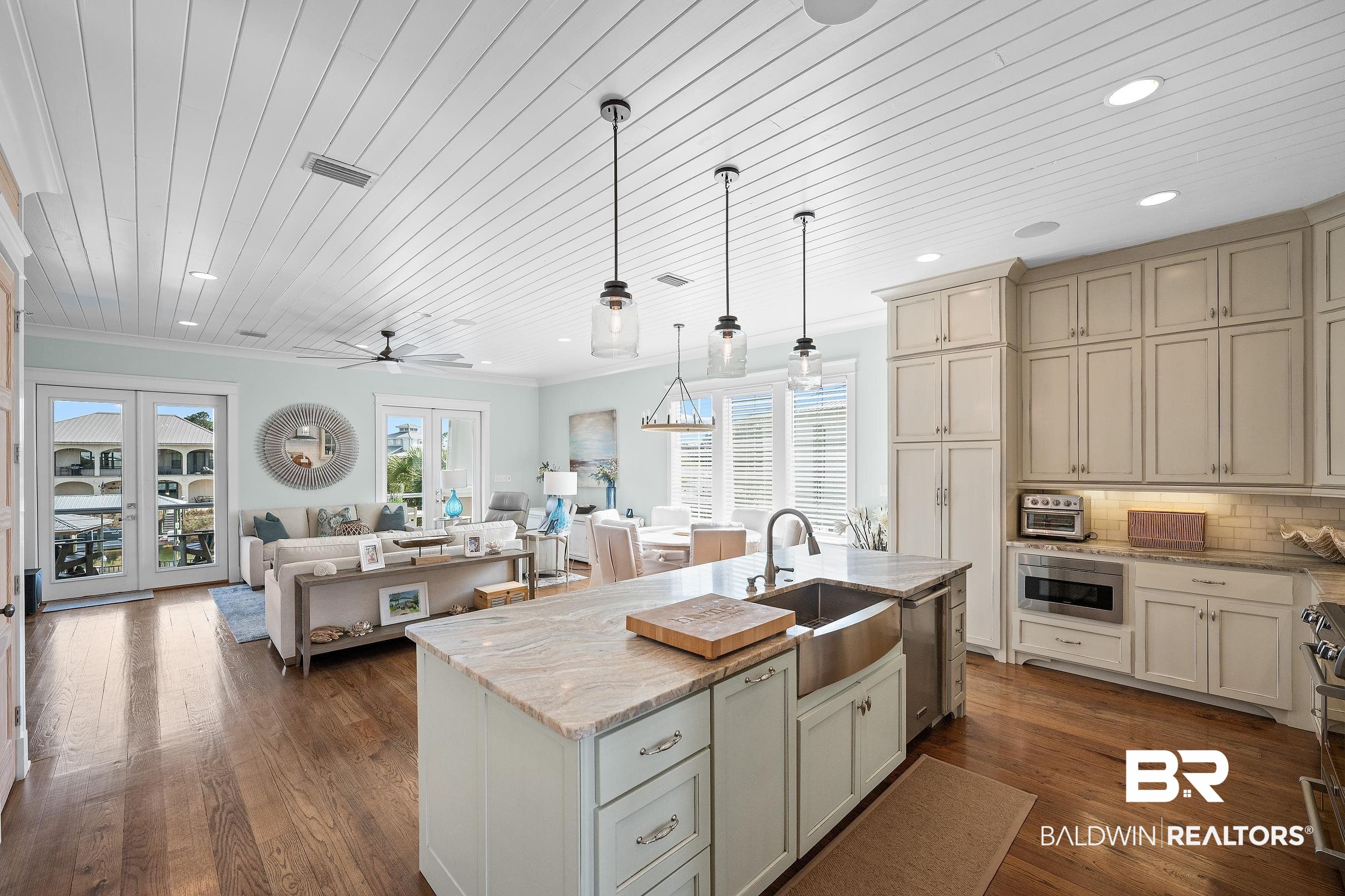 33186 Marlin Key Drive Orange Beach, AL 36561 - Photo 84 of 87 Kitchen featuring open floor plan, light stone counters, pendant lighting, a kitchen island with sink, and wood ceiling