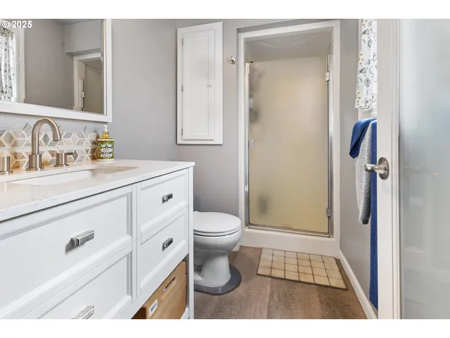 a bathroom with a sink a toilet and shower