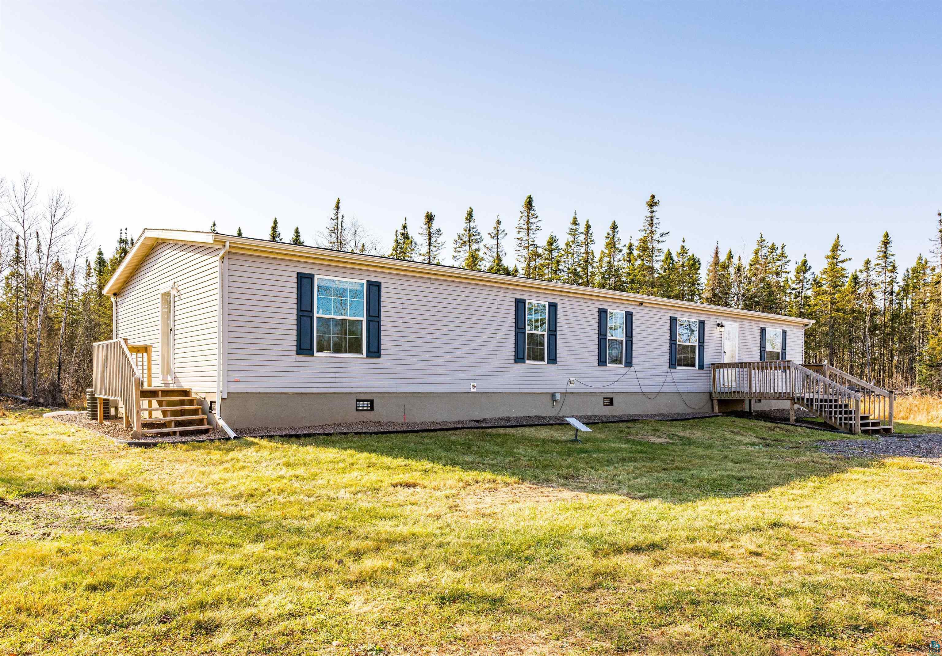 Rear view of house with a wooden deck and a yard